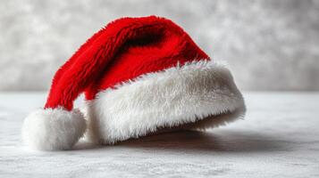 A festive red and white Santa hat rests on a textured surface, evoking the cheerful spirit of the holiday season during winter celebrations photo