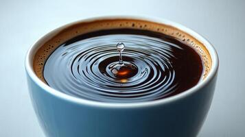 A drop of liquid dances above dark coffee, creating delicate ripples in a tranquil setting photo