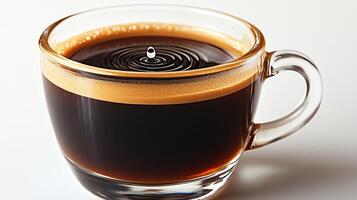 Dark, aromatic coffee fills a clear cup, where droplets create gentle ripples atop a frothy surface photo