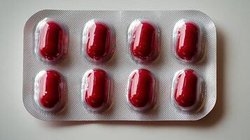 Glossy red capsules arranged neatly in a blister pack, highlighting their pharmaceutical appeal photo