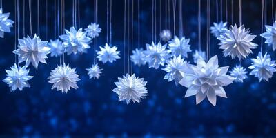 A mesmerizing and enchanting scene emerges, featuring delicate white paper snowflakes gracefully suspended against a rich deep blue backdrop, together creating an inviting winter wonderland ambiance photo