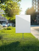 Blank sign on grass in front of a building photo