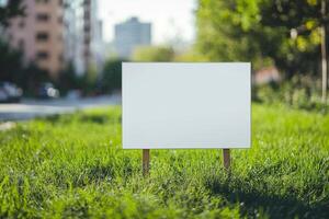 Blank sign on grass in front of city photo