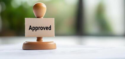 Approved stamp on wooden base signifies validation and acceptance, often used in official documents and processes photo