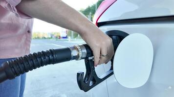 A person refuels a car at a gas station, highlighting energy consumption and travel expenses during summer road trips photo