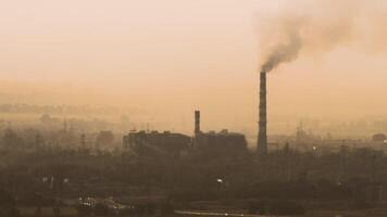 Dramatic sunset over industrial area. A silhouette of an industrial complex with tall smokestacks against a setting sun video