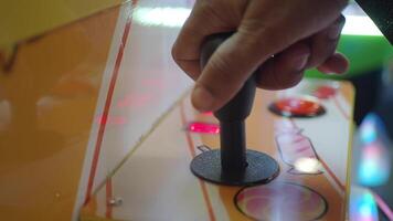 A hand expertly maneuvering an arcade joystick on a vibrant and colorful gaming machine video