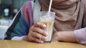 Enjoying a refreshing, chilled iced coffee drink while relaxing in a cozy cafe setting video
