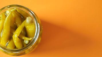 Top View of Pickled Peppers in a Jar on Orange Background video