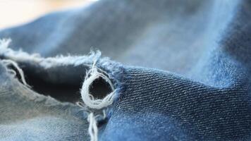 blue jean texture with a hole and ripped threads showing video