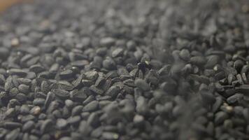 slow motion of dropping Black Seeds in a container video