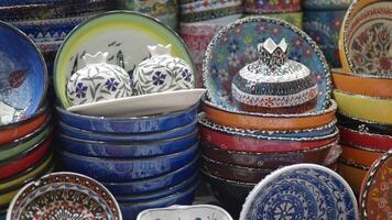A beautiful array of colorful handpainted ceramic bowls elegantly displayed for sale video