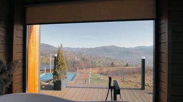 Luxurious bathtub in a wooden interior with panoramic mountain views. Bathtub with mountain view video