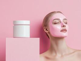 White cosmetic jar on pastel pink background with a young woman's face in pink clay mask. Soft pink and white colors. Minimalistic photo style.