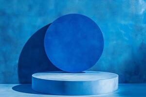 Blue rounded podium on a bright blue background. Minimalistic photo style. Modern abstract geometric shapes.