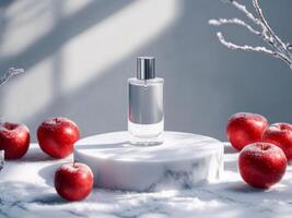 Transparent perfume bottle on white podium on marble table. Snow and frosty red apples around. Minimalistic photo style.