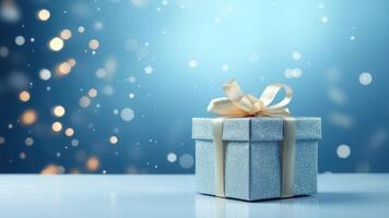 blue gift box with gold bow on blue background and empty space photo