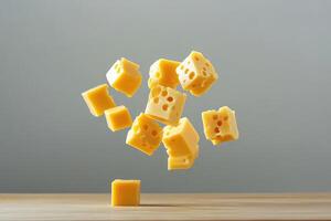 Cubes of Swiss Cheese Falling Towards a Wooden Surface photo