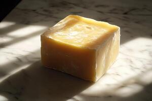 A Block of Pale Yellow Wax on a Marble Surface photo