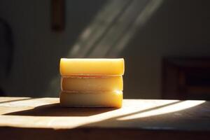 Stack of Three Round Yellow Cheeses in Sunlight photo