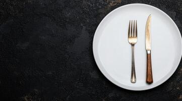 elegant dining setting with white plate and cutlery on dark background photo