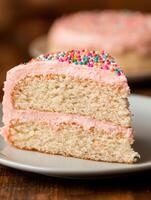 Delicious pink frosted cake with colorful sprinkles photo