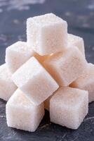 Closeup of white sugar cubes on dark background photo