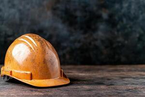Worn construction hard hat on wooden table photo