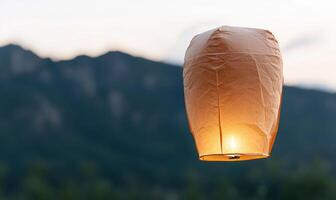Glowing paper lantern in the mountains at sunset photo