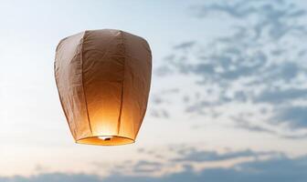Glowing paper lantern floating in the sky photo