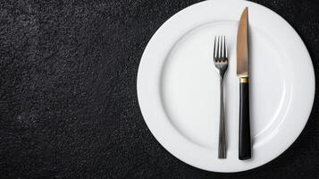 Elegant place setting with white plate and silverware on dark background photo