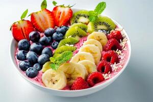 Colorful fruit salad bowl with strawberries, blueberries, kiwi, banana, and raspberries photo
