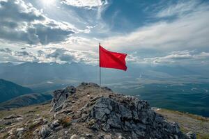 Red flag on mountain peak with dramatic cloudy sky photo