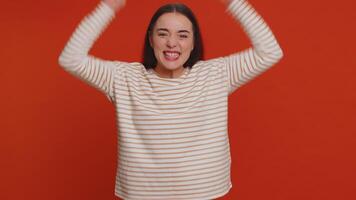 Stylish woman in pullover shouting, raising fists in gesture I did it, celebrating success, winning video