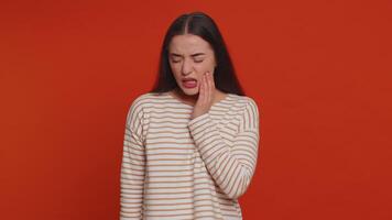 Woman touching cheek suffering from toothache cavities or gingivitis waiting for dentist appointment video