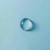 Minimalist image of a single water droplet on a blue surface photo