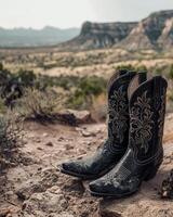 Cowboy boots in a rugged desert landscape photo