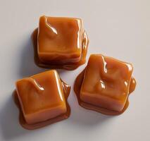 Glossy caramel candies on a smooth surface photo