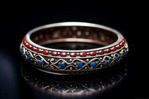 Elegant vintage bangle with intricate designs on a reflective surface photo