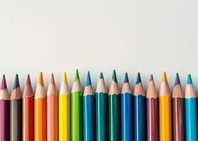 Colorful array of sharpened pencils lined up against a white background photo