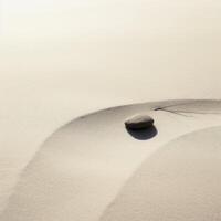 Zen stone on smooth sand with delicate shadow photo