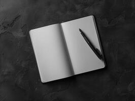 Open notebook with pen on a dark textured surface photo