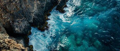 Aerial View of Waves Crashing Against Rocky Cliffs photo