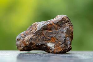 Close up of a textured rock on a blurred green background photo