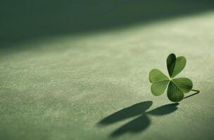 Single four leaf clover casting a shadow on a textured surface photo