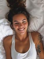 Young woman smiling while lying in bed photo
