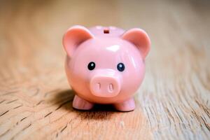 Pink piggy bank on wooden surface photo