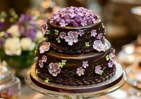 Elegant chocolate cake decorated with purple flowers on display photo