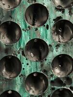 Abstract texture of black spheres on a green corroded metal surface photo
