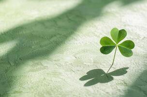 Four leaf clover casting a shadow on a textured surface photo